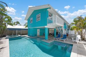 a house with a swimming pool in front of a house at Hidden Treasure Unit A! Modern duplex with shared pool just 200 steps to the beach! in Bradenton Beach