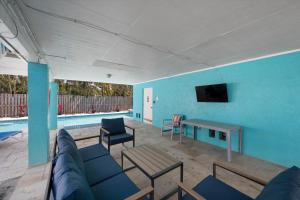 a living room with a couch and a table and a tv at Hidden Treasure Unit A! Modern duplex with shared pool just 200 steps to the beach! in Bradenton Beach