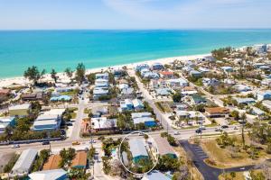 an aerial view of a parking lot next to the beach at Hidden Treasure Unit A! Modern duplex with shared pool just 200 steps to the beach! in Bradenton Beach