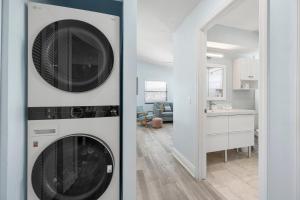 two washer and dryers in a living room at Hidden Treasure Unit A! Modern duplex with shared pool just 200 steps to the beach! in Bradenton Beach
