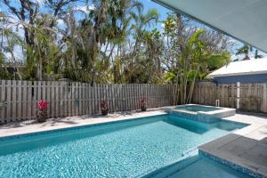 a swimming pool in a backyard with a fence at Hidden Treasure Unit A! Modern duplex with shared pool just 200 steps to the beach! in Bradenton Beach