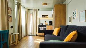a living room with a blue couch and a kitchen at Greta Hillside in Buceş-Vulcan