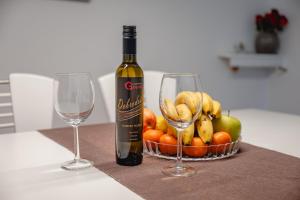 a bottle of wine and two wine glasses on a table at Apartma Golob in Maribor
