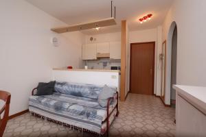 a living room with a couch and a kitchen at Oasi blu - Charme nel cuore della pineta in Grado-Pineta