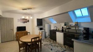 a kitchen with a table and a small kitchen with a table and chairs at L'annexe in Savoisy