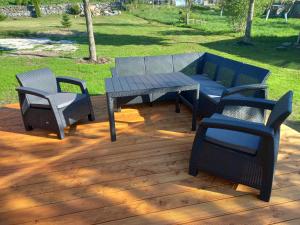 a patio with a table and chairs on a wooden deck at Domek U Babci in Istebna