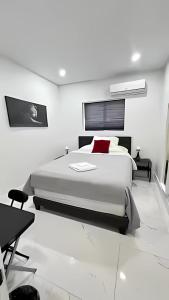 a white bedroom with a large bed with red pillows at Cozy Private Room, near the Airport - Free parking - 01 in Miami