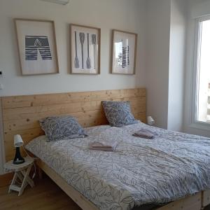 ein Schlafzimmer mit einem großen Bett mit drei Bildern an der Wand in der Unterkunft La Marinière, appartement avec garage, 2 étoiles à 100m de la mer in Barneville-Carteret