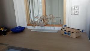 ein Raum mit einem Fenster mit einem Ventilator und einer Kiste in der Unterkunft La Marinière, appartement avec garage, 2 étoiles à 100m de la mer in Barneville-Carteret + 35 Fotos