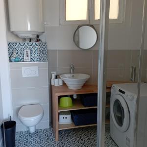 ein Badezimmer mit Waschbecken und Waschmaschine in der Unterkunft La Marinière, appartement avec garage, 2 étoiles à 100m de la mer in Barneville-Carteret