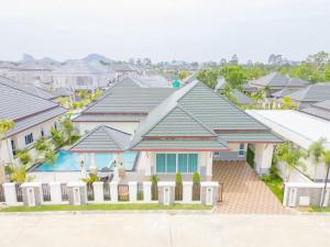 una casa con una valla blanca delante de las casas en Siam Pool Villa, Pattaya, en Na Jomtien