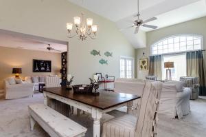 - un salon avec une table en bois et un mobilier blanc dans l'établissement License to Chill by Bryant Real Estate, à Carolina Beach