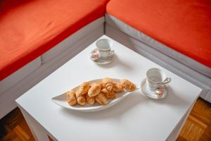 a table with a plate of cookies and two cups at Apartma Golob in Maribor +39 photos