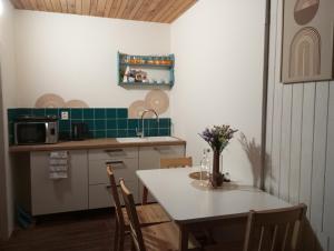 cocina con mesa y sillas y cocina con azulejos verdes en Chata pre hostí s ohniskom, en Spišská Nová Ves 3 fotos más