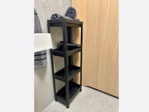 a black shelf in a bathroom next to a door at Jungle Apartment in Krakow