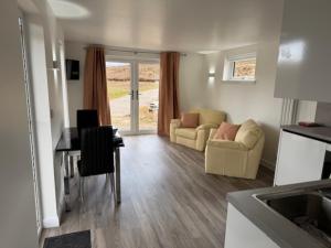a kitchen and living room with a table and chairs at Ledgowan Bunkhouse in Achnasheen