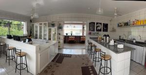 a kitchen with a bar with stools in it at Hotel Picadão in São Pedro