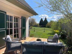 a patio with two chairs and a couch on a deck at Ferienhaus Schiffchen "Unter Deck" in Prerow