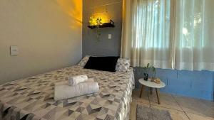 a bedroom with a large bed and a table at Loft no Morro da Borussia I in Osório