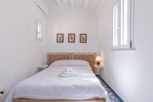 a white bedroom with a bed and two windows at Zisa Top Romantic Terrace & Private outdoor Jacuzzi in Palermo +27 photos