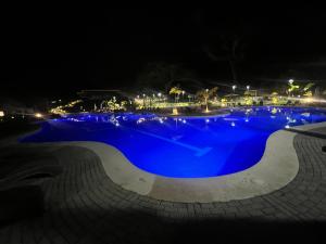 a large pool with blue water at night at Namú Apartment in Herradura +2 photos