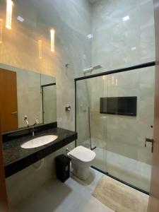 a bathroom with a toilet and a sink and a shower at Apartamento novo no centro de Sinop! in Sinop