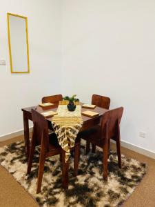 a dining room table with four chairs and a mirror at Sun Sky Negombo Serviced Apartment in Negombo