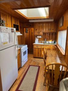 a kitchen with a white refrigerator and a table at Cowboy's Trail with HotTub, King&QueenBed, in UpperCanyon, Pets welcome in Ruidoso