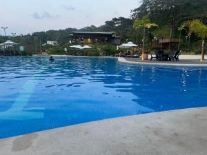 a large swimming pool with blue water at Namú Apartment in Herradura