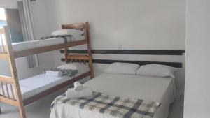 a room with two bunk beds and a table at Hospedagem Clima Mar Guaibim in Valença