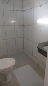 a white bathroom with a toilet and a sink at Hospedagem Clima Mar Guaibim in Valença +41 photos
