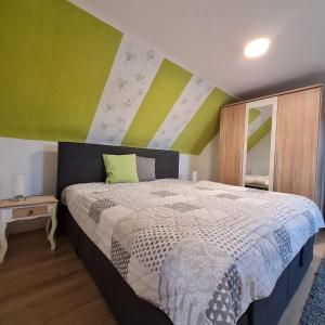 a bedroom with a bed and a green and white wall at Ferienhaus am Fuchsberg in Dahme