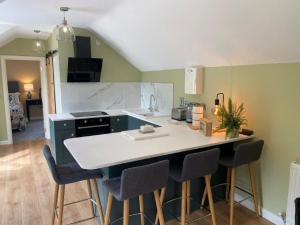 a kitchen with a counter and chairs in a room at Sea View Upper Apartment in Greencastle