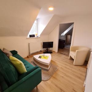 a living room with a green couch and a coffee table at Ferienhaus am Fuchsberg in Dahme