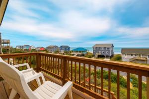 a balcony with two chairs and a view of the ocean at Beachside 4bdrm Emerald Isle in Emerald Isle
