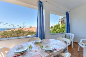 a dining room with a table and views of the ocean at Casa Vacanza Costa del Sole in Pomonte