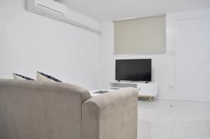 a living room with a couch and a television at Alexandra Park Motor Inn in Bundaberg
