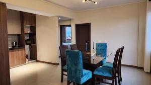 a dining room with a table and blue chairs at Beautiful and central apartment in Tarija