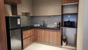 a kitchen with a refrigerator and a sink in it at Beautiful and central apartment in Tarija +3 photos