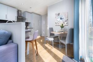 una cucina e una sala da pranzo con tavolo e sedie di Silverdale Lodge, HotTub, Wi-FI, Quiet & Sleeps 4 a Warton