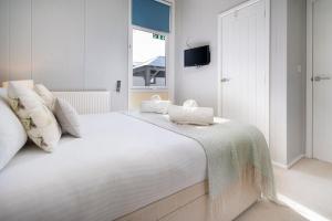 una camera bianca con un grande letto bianco e una finestra di Silverdale Lodge, HotTub, Wi-FI, Quiet & Sleeps 4 a Warton Altre 11 foto