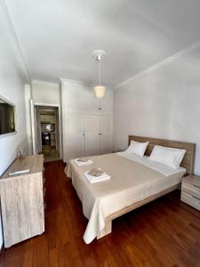 a bedroom with a large bed and a wooden floor at Rosie Apartment in Preveza