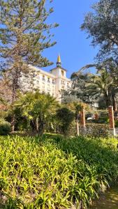 ein großes Gebäude mit einem Turm darauf in der Unterkunft Appartement Ombragé 44m2 Riviera Palace Belle-Epoque, Restomod et Literie Prestige in Menton