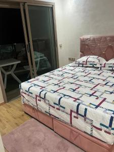 a bed with a quilt on it in a bedroom at appartement de lux vue piscine 5 min plage bouznika in Bouznika