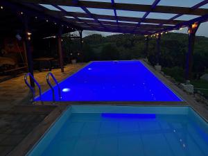 a large blue swimming pool under a pergola at Agroturystyka Faron in Rozdziele