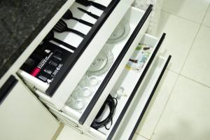 a drawer in a refrigerator filled with dishes at Residential House in Anápolis in Anápolis