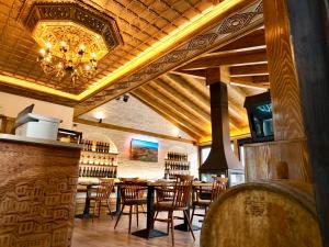 a restaurant with a table and chairs and a chandelier at HOTEL ANSEL in Berat