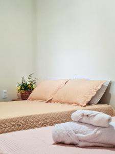 une chambre avec un lit avec des serviettes dessus dans l'établissement Hospedaria Oliveira - Santo Amaro do Maranhão, à Queimada