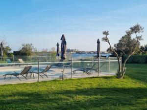 a group of chairs and a pool with a sculpture at Ariane Hôtel Fos sur Mer in Fos-sur-Mer