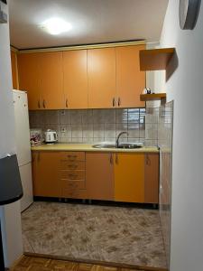 a kitchen with orange cabinets and a sink at Magdalena in Vranješ +9 photos